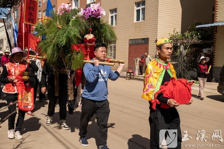 村民手捧土主印走在巡游队伍前面。